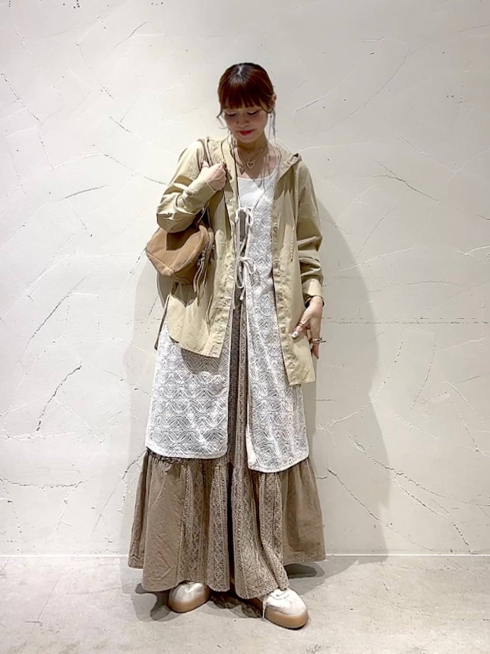 イエロー系のスカート、ベージュ系のボストンバッグ、ベージュ系のワンピースを着用したレディースの秋コーディネートの7枚目の写真