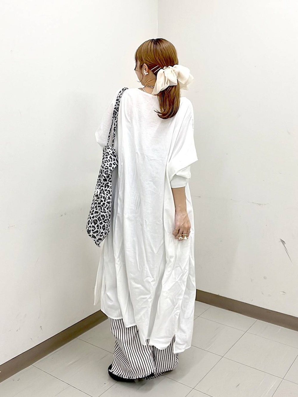 その他のトートバッグ、ブラック系のパンプス、ホワイト系のデニムパンツを着用したレディースの冬コーディネートの4枚目の写真