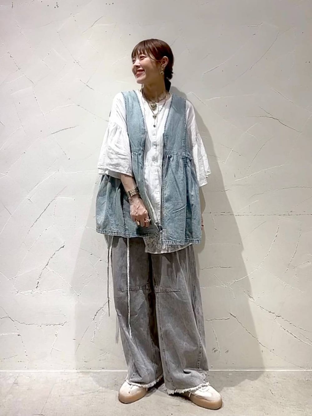 グレー系のその他パンツ、ブルー系のベスト、ホワイト系のシャツ/ブラウスを着用したレディースの夏コーディネートの7枚目の写真