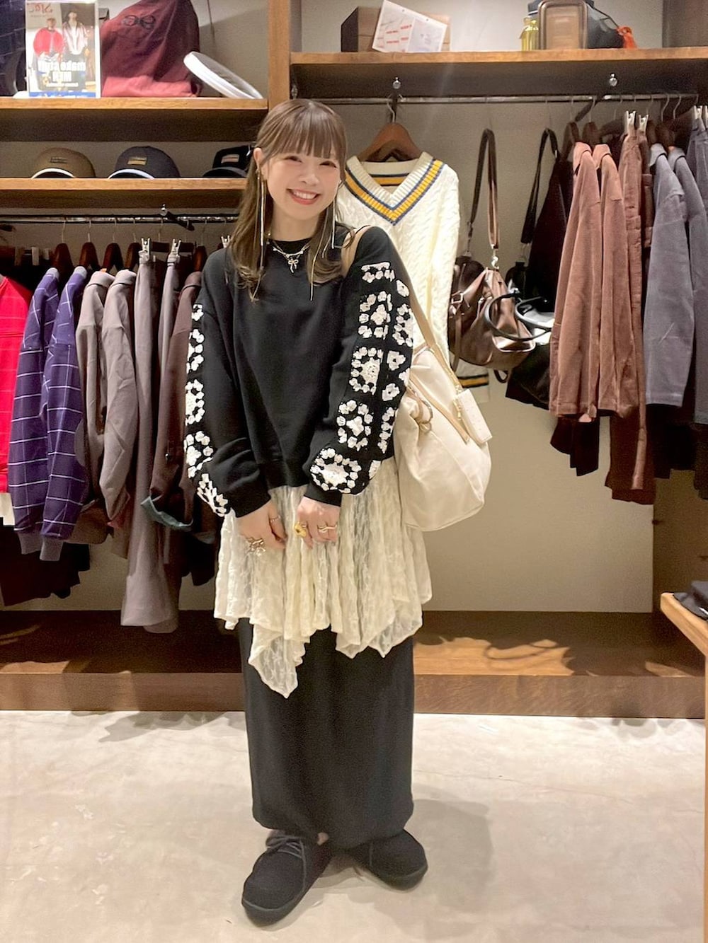 ベージュ系のワンピース、ブラック系のスウェット、ブラック系のモカシン/デッキシューズを着用したレディースの秋コーディネートの3枚目の写真