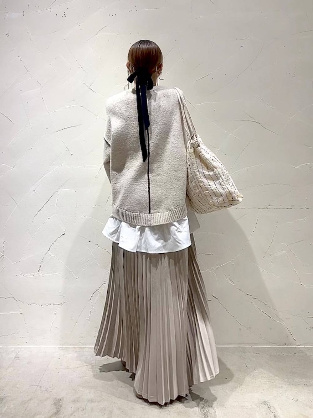 ベージュ系のスカート、その他のトートバッグ、ゴールド系のネックレスを着用したレディースの秋コーディネートの4枚目の写真