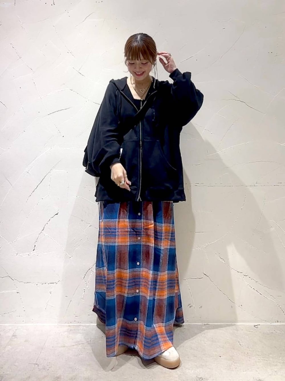 ブラック系のショルダーバッグ、イエロー系のネックレスを着用したレディースの秋コーディネートの3枚目の写真