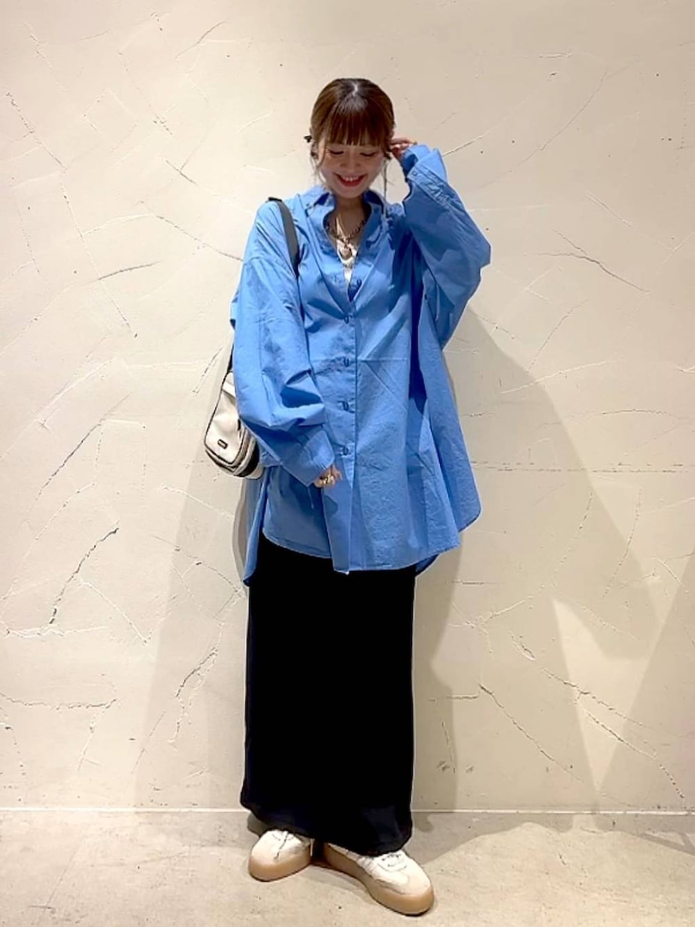 ブラック系のスカート、ブルー系のシャツ/ブラウス、ベージュ系のショルダーバッグを着用したレディースの夏コーディネートの2枚目の写真