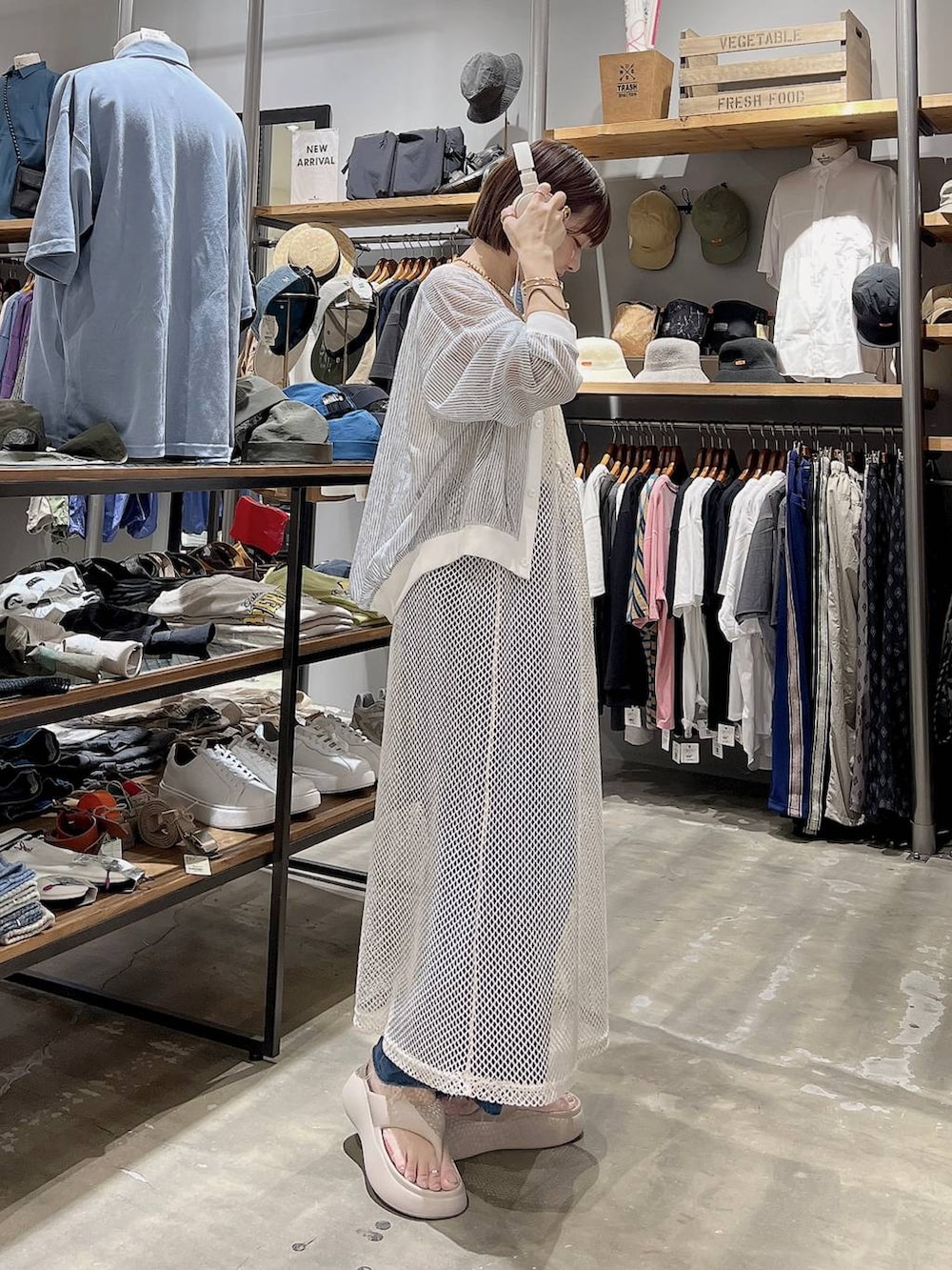 ベージュ系のサンダル、ホワイト系のカーディガン/ボレロ、ブルー系のデニムパンツを着用したレディースの夏コーディネートの2枚目の写真