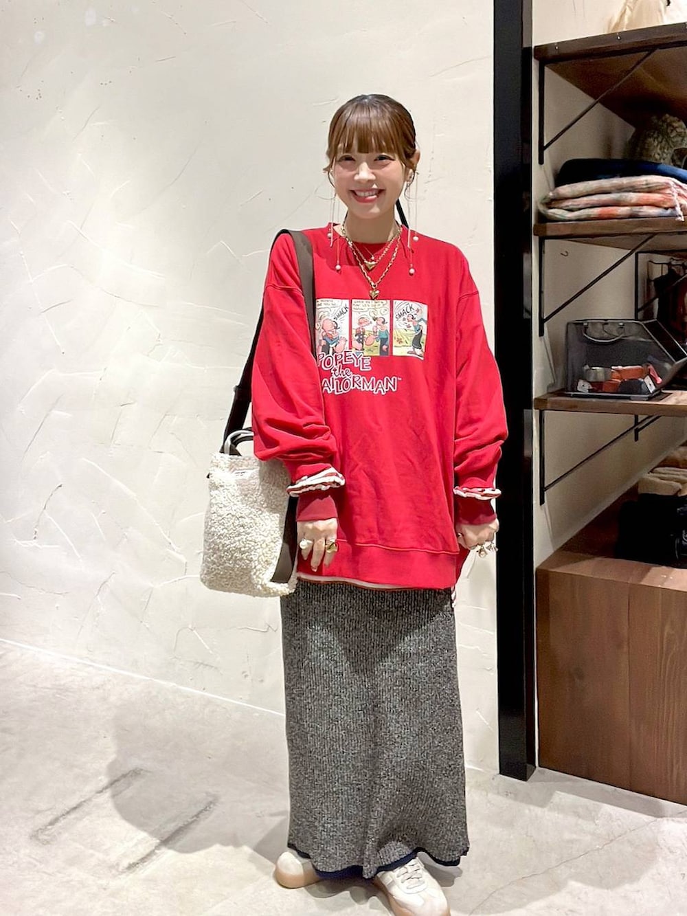 レッド系のTシャツ/カットソー、ホワイト系のスカート、ベージュ系のトートバッグを着用したレディースの冬コーディネートの2枚目の写真