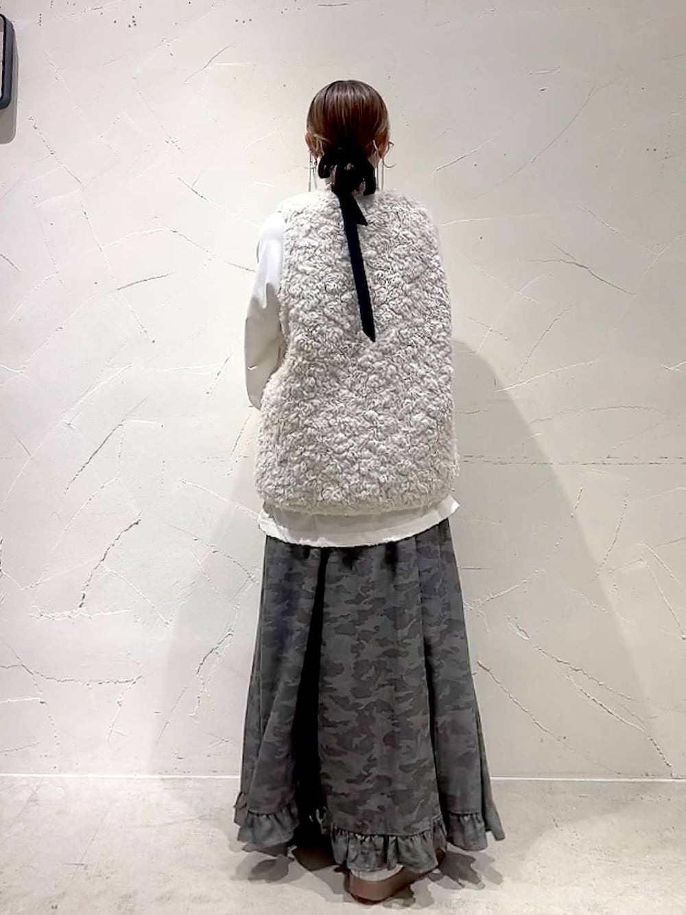 ベージュ系のベスト、その他のトートバッグ、グリーン系のスカートを着用したレディースの秋コーディネートの5枚目の写真