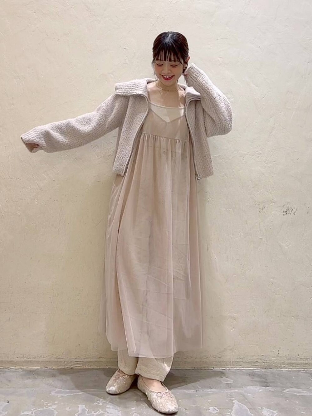 ベージュ系のワンピース、ホワイト系のその他パンツ、ホワイト系のバレエシューズを着用したレディースの冬コーディネートの6枚目の写真