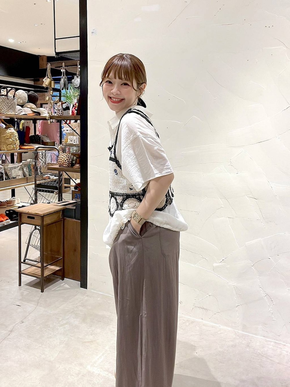 イエロー系のトートバッグ、ホワイト系のキャミソール、ホワイト系のシャツ/ブラウスを着用したレディースの夏コーディネートの7枚目の写真