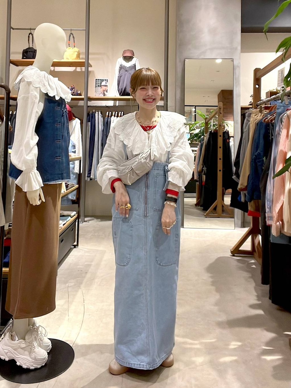 ブルー系のジャンパースカート、ベージュ系のTシャツ/カットソー、ホワイト系のシャツ/ブラウスを着用したレディースの冬コーディネートの2枚目の写真