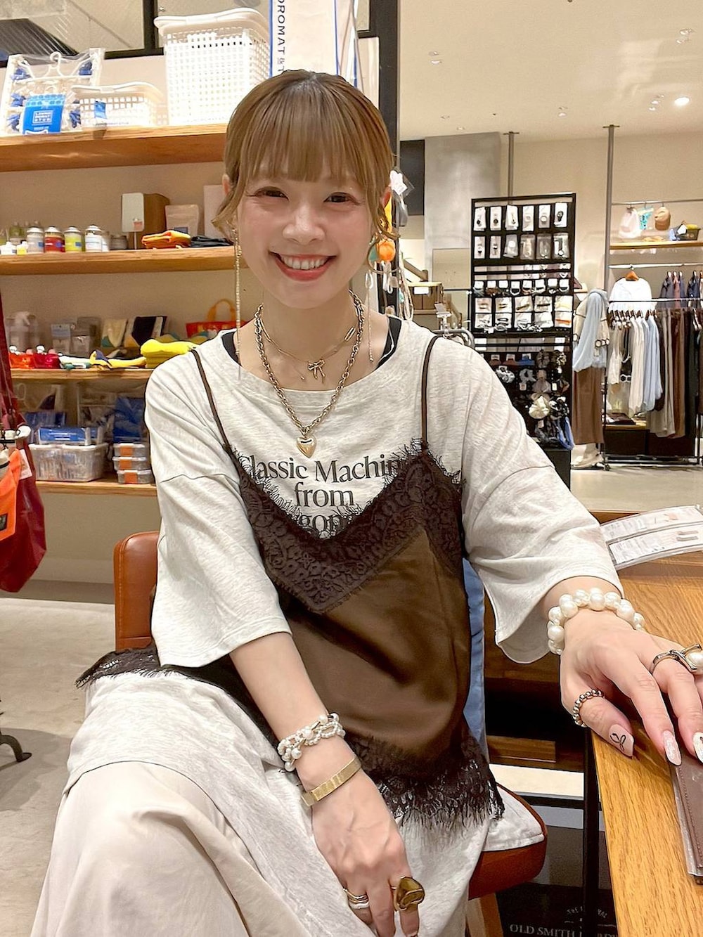 ホワイト系のタンクトップ、ベージュ系のスカート、ブラウン系のキャミソールを着用したレディースの夏コーディネートの3枚目の写真