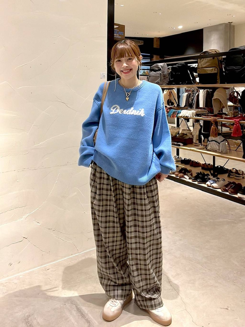 ブラウン系のその他パンツ、ブルー系のニット/セーター、ベージュ系のボストンバッグを着用したレディースの秋コーディネートの8枚目の写真