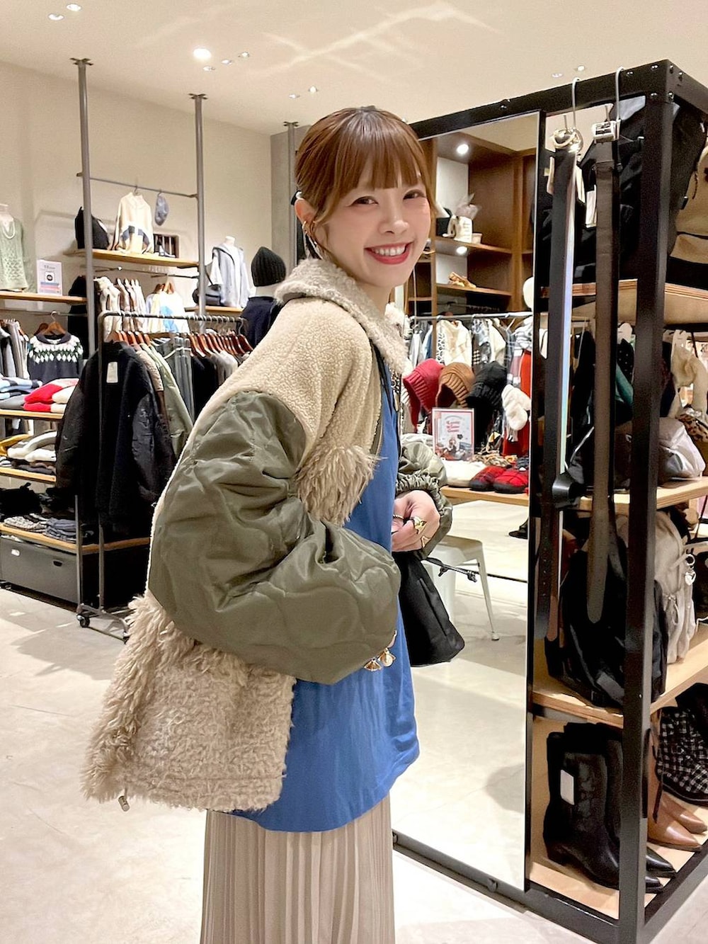 ブルー系のTシャツ/カットソー、ベージュ系のスカート、ベージュ系のブルゾンを着用したレディースの秋コーディネートの4枚目の写真