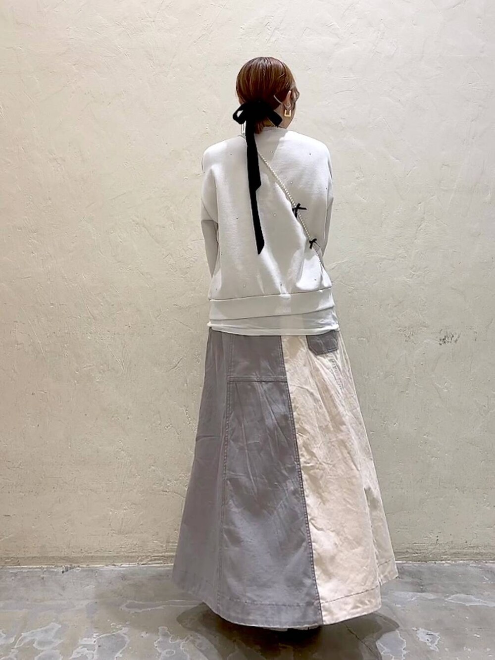 ゴールド系のショルダーバッグ、ホワイト系のTシャツ/カットソー、ホワイト系のその他トップスを着用したレディースの冬コーディネートの5枚目の写真