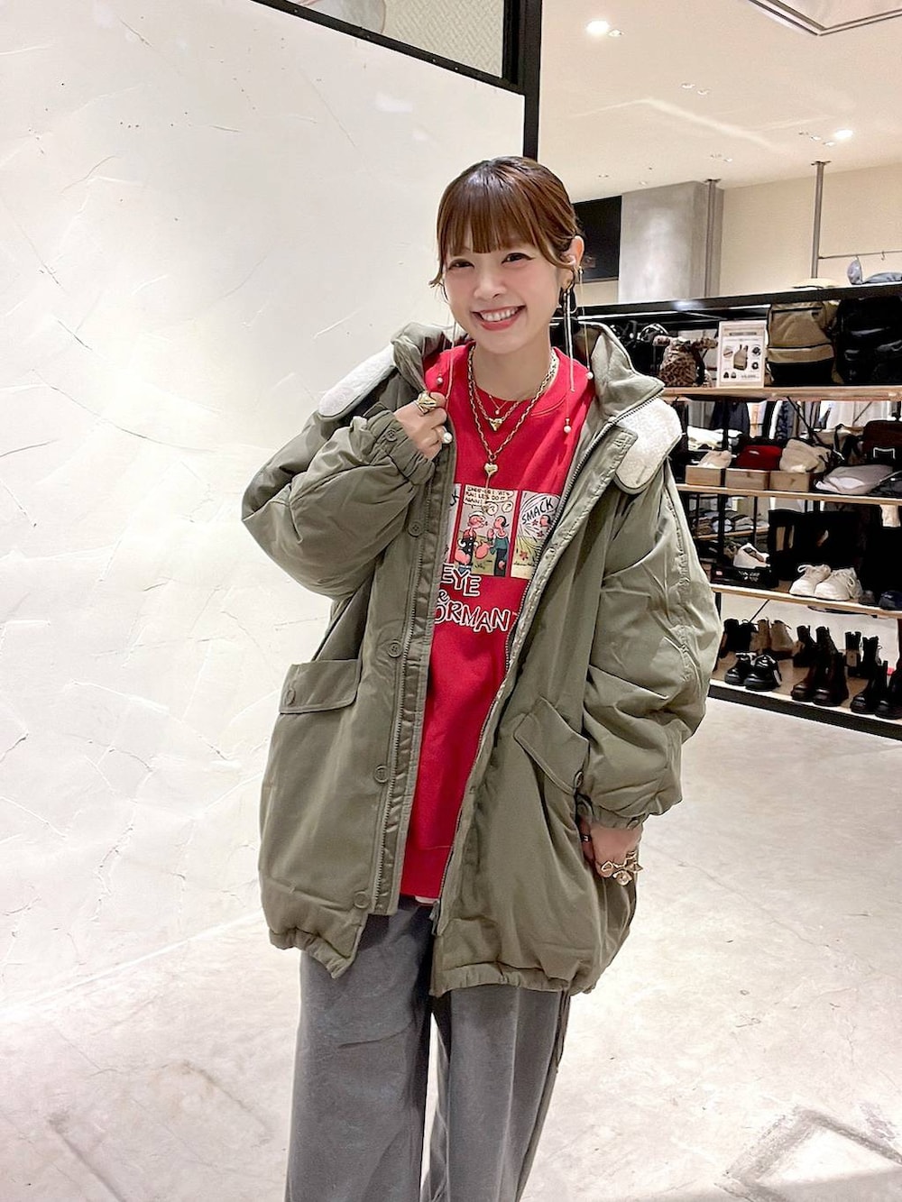 グリーン系のブルゾン、グレー系のその他パンツ、レッド系のスウェットを着用したレディースの冬コーディネートの8枚目の写真