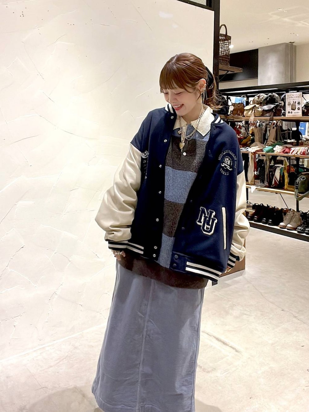 ゴールド系のスニーカー、ブルー系のスカート、ブルー系のブルゾンを着用したレディースの秋コーディネートの7枚目の写真