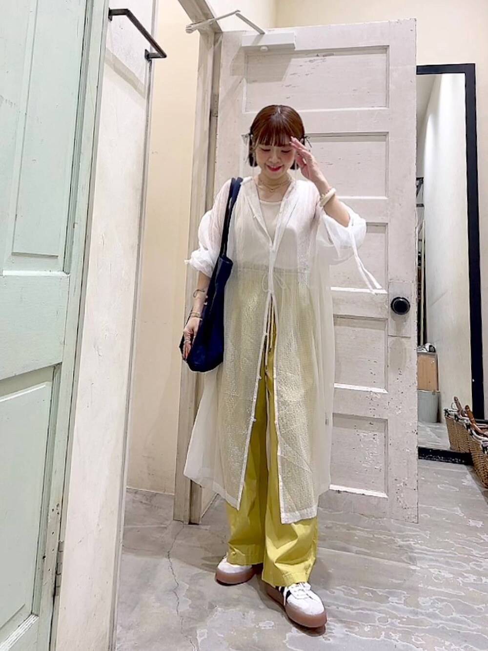 ブルー系のトートバッグ、イエロー系のその他パンツ、ホワイト系のワンピースを着用したレディースの夏コーディネートの2枚目の写真