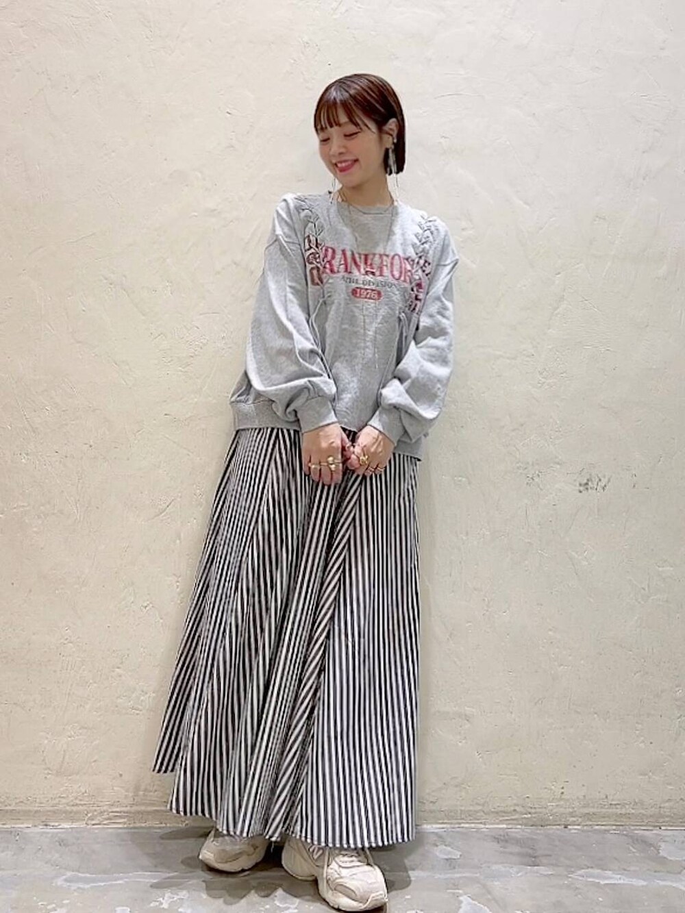 グレー系のTシャツ/カットソー、ブルー系のスカートを着用したレディースの春コーディネートの6枚目の写真