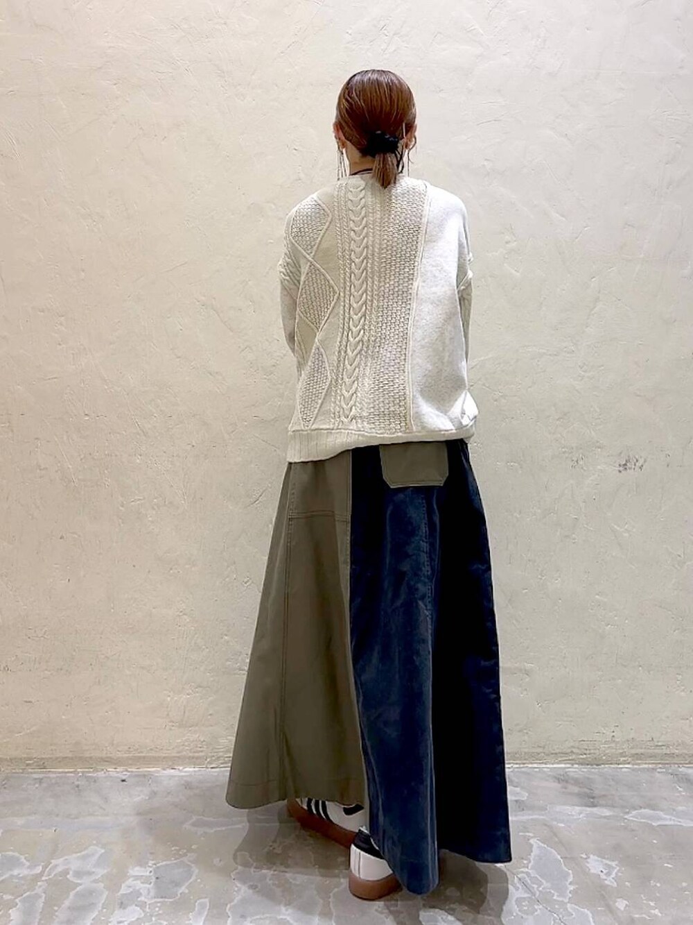 その他のショルダーバッグ、ベージュ系のニット/セーター、グリーン系のスカートを着用したレディースの冬コーディネートの5枚目の写真