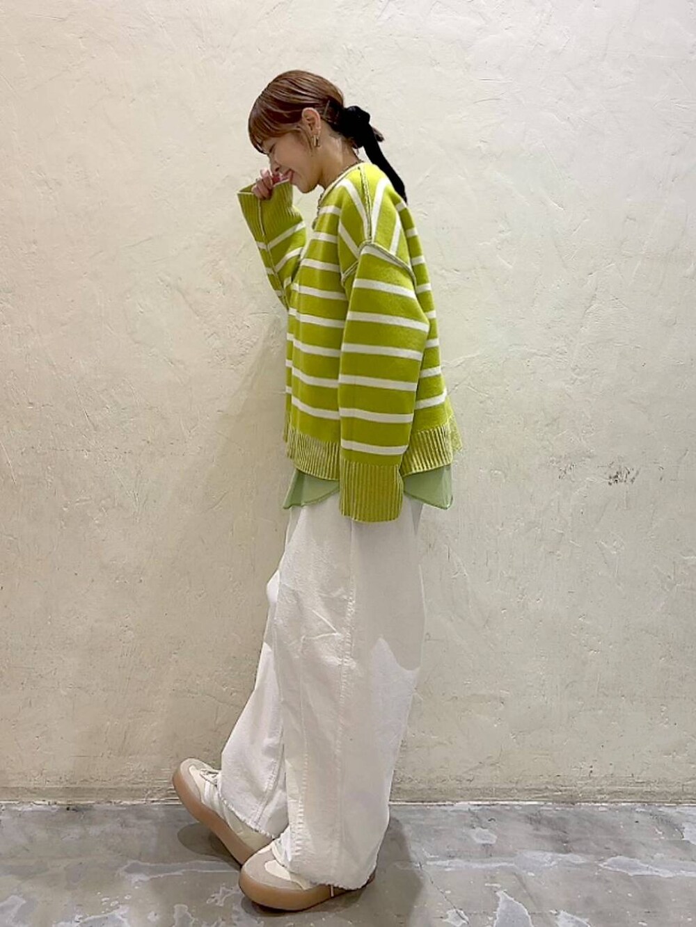 ホワイト系のその他パンツ、シルバー系のショルダーバッグ、イエロー系のニット/セーターを着用したレディースの冬コーディネートの6枚目の写真