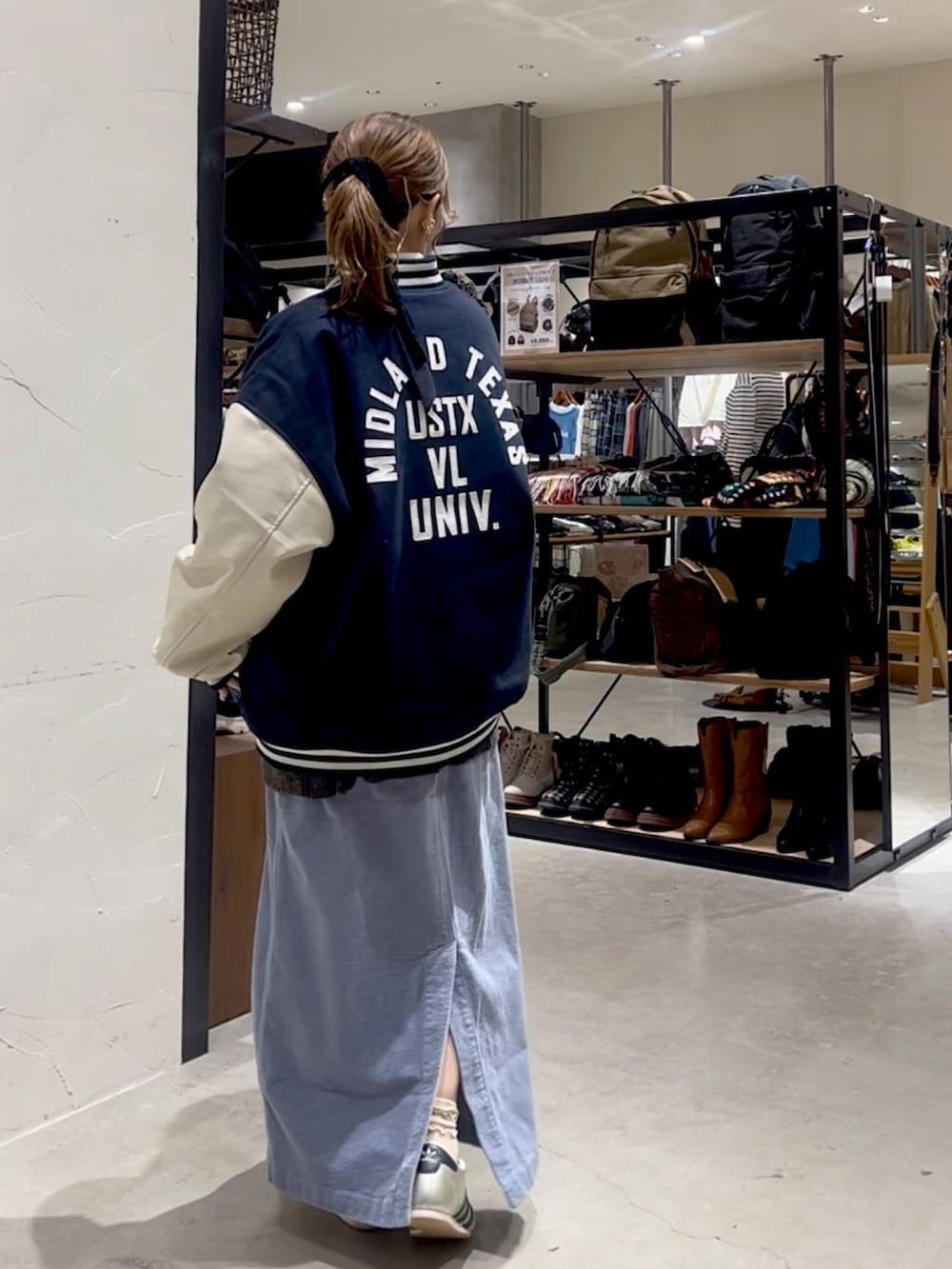 ゴールド系のスニーカー、ブルー系のスカート、ブルー系のブルゾンを着用したレディースの秋コーディネートの5枚目の写真