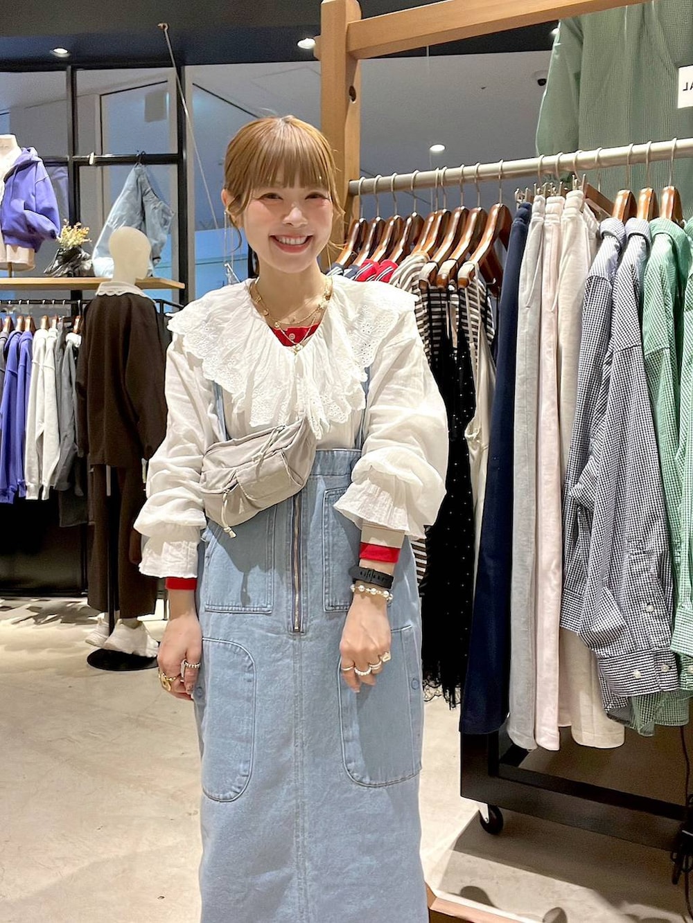 ブルー系のジャンパースカート、ベージュ系のTシャツ/カットソー、ホワイト系のシャツ/ブラウスを着用したレディースの冬コーディネートの5枚目の写真