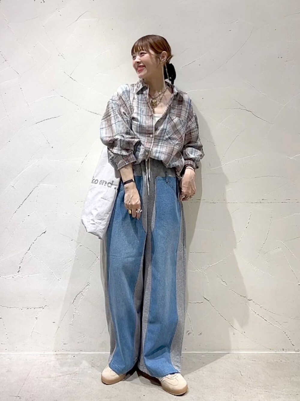 ベージュ系のシャツ/ブラウス、グレー系のトートバッグ、グレー系のデニムパンツを着用したレディースの夏コーディネートの2枚目の写真