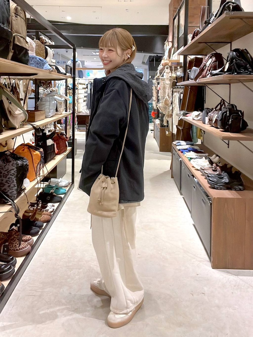 ベージュ系のデニムパンツ、ベージュ系のショルダーバッグ、グレー系のその他アウターを着用したレディースの春コーディネートの6枚目の写真