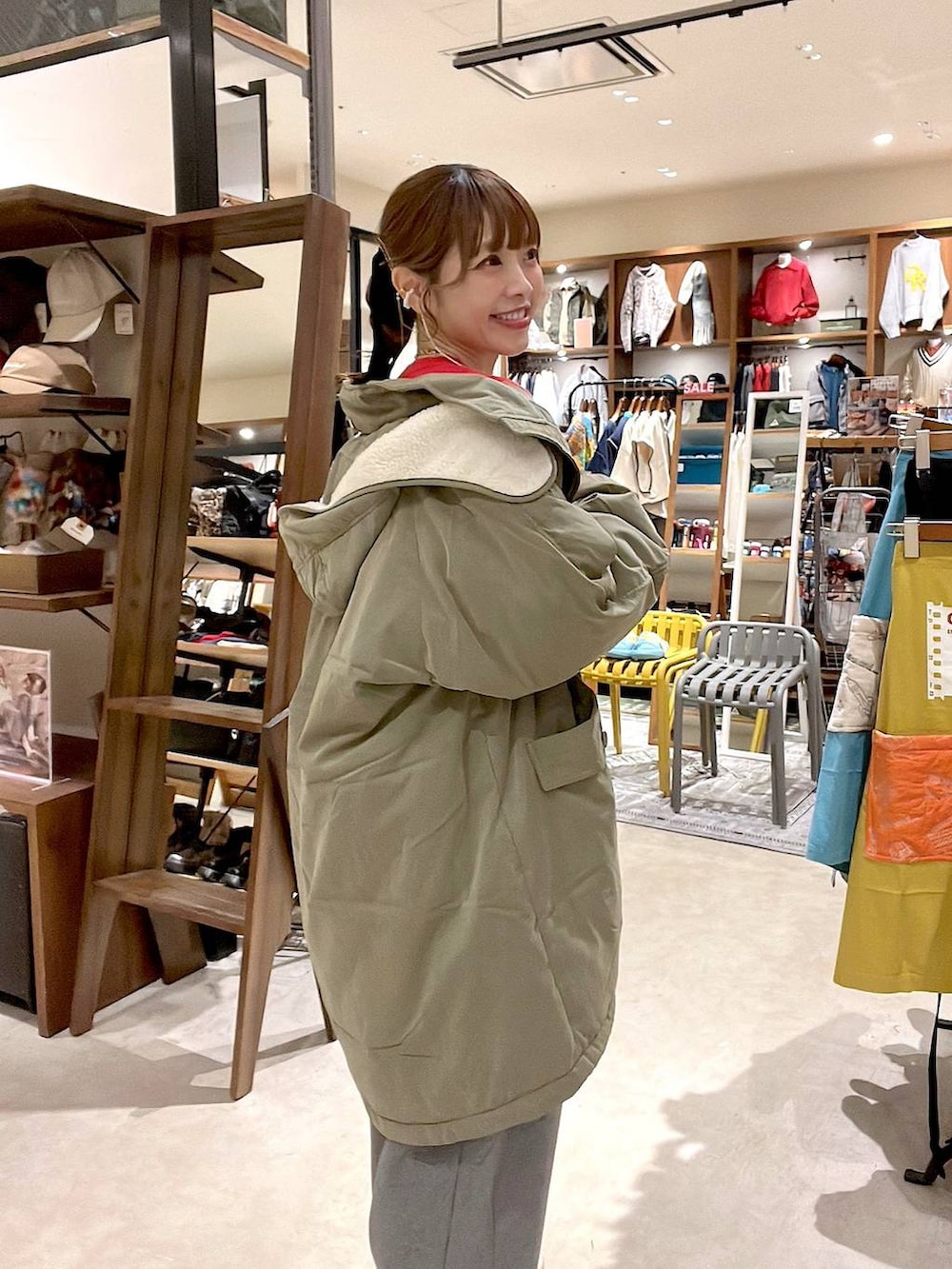 グリーン系のブルゾン、グレー系のその他パンツ、レッド系のスウェットを着用したレディースの冬コーディネートの5枚目の写真