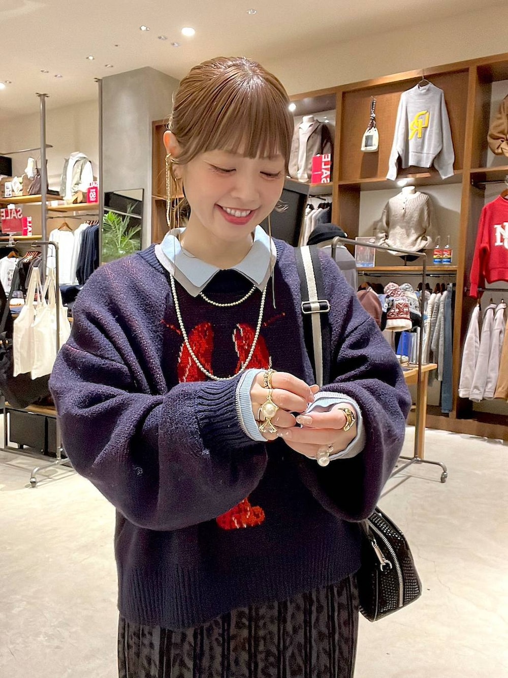 グレー系のスカート、ブラック系のショルダーバッグ、ベージュ系のスニーカーを着用したレディースの冬コーディネートの7枚目の写真