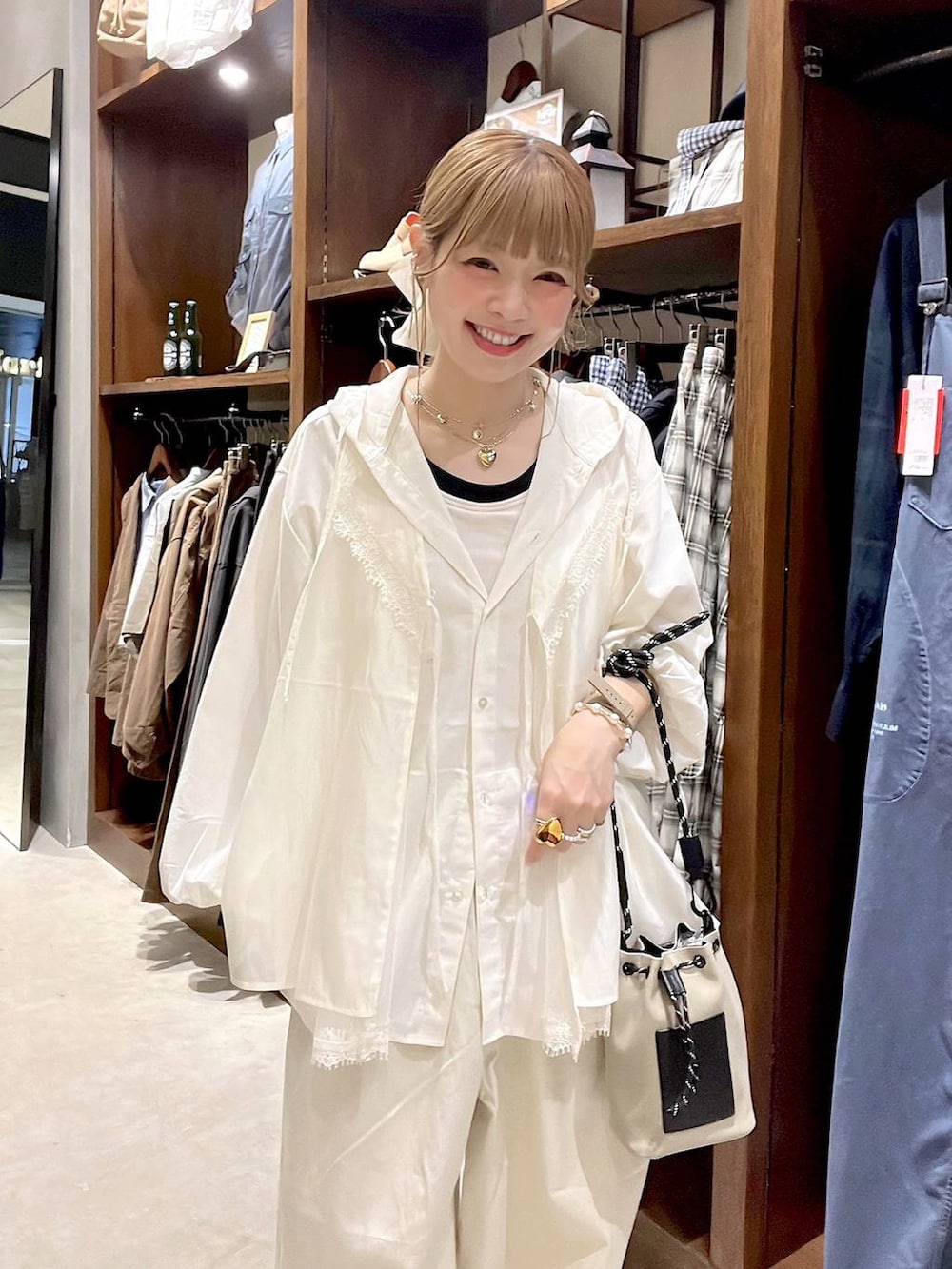 グレー系のショルダーバッグ、ホワイト系のシャツ/ブラウス、ホワイト系のベストを着用したレディースの春コーディネートの6枚目の写真