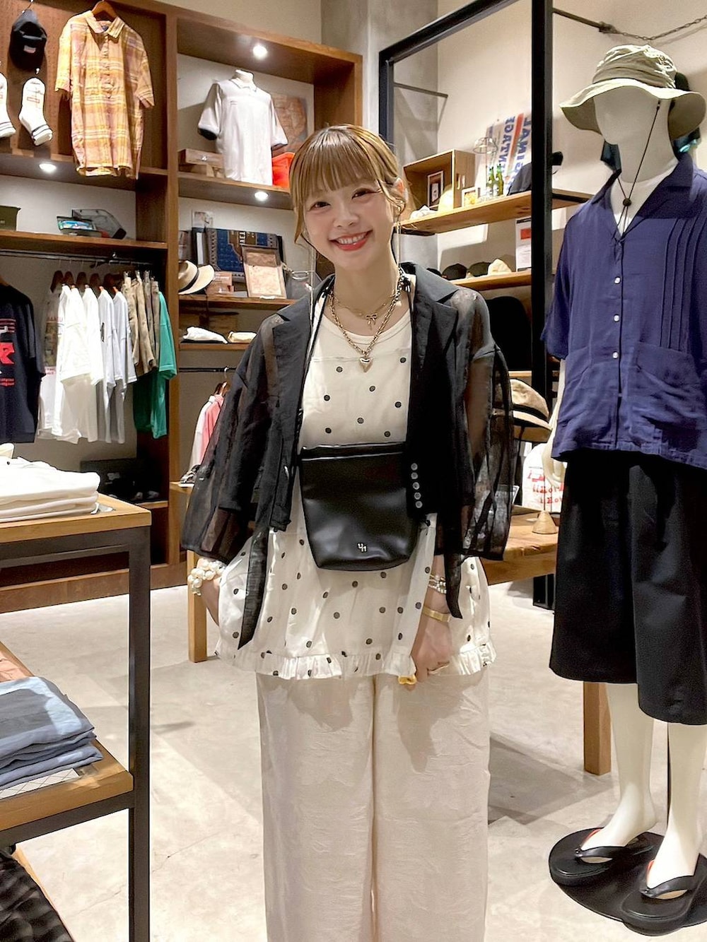 ホワイト系のタンクトップ、ベージュ系のその他パンツ、ブラック系のショルダーバッグを着用したレディースの夏コーディネートの3枚目の写真