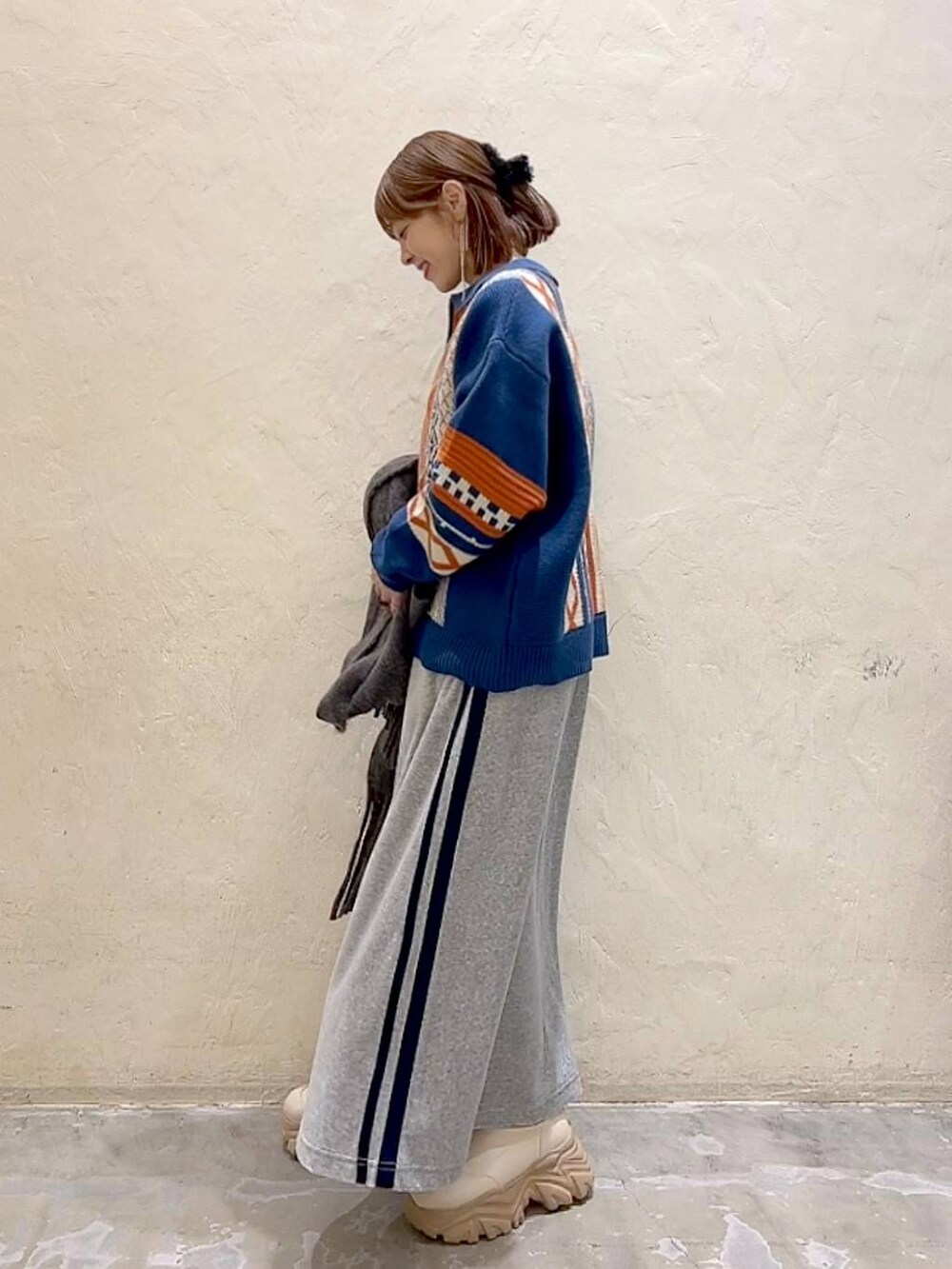 ブルー系のニット/セーター、グレー系のストール/ショール、ブラック系のバレッタ/ヘアクリップを着用したレディースの秋コーディネートの7枚目の写真