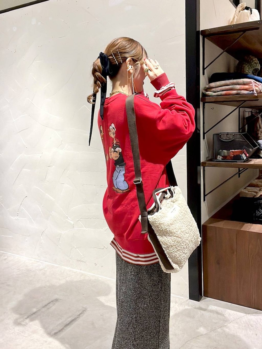 レッド系のTシャツ/カットソー、ホワイト系のスカート、ベージュ系のトートバッグを着用したレディースの冬コーディネートの6枚目の写真