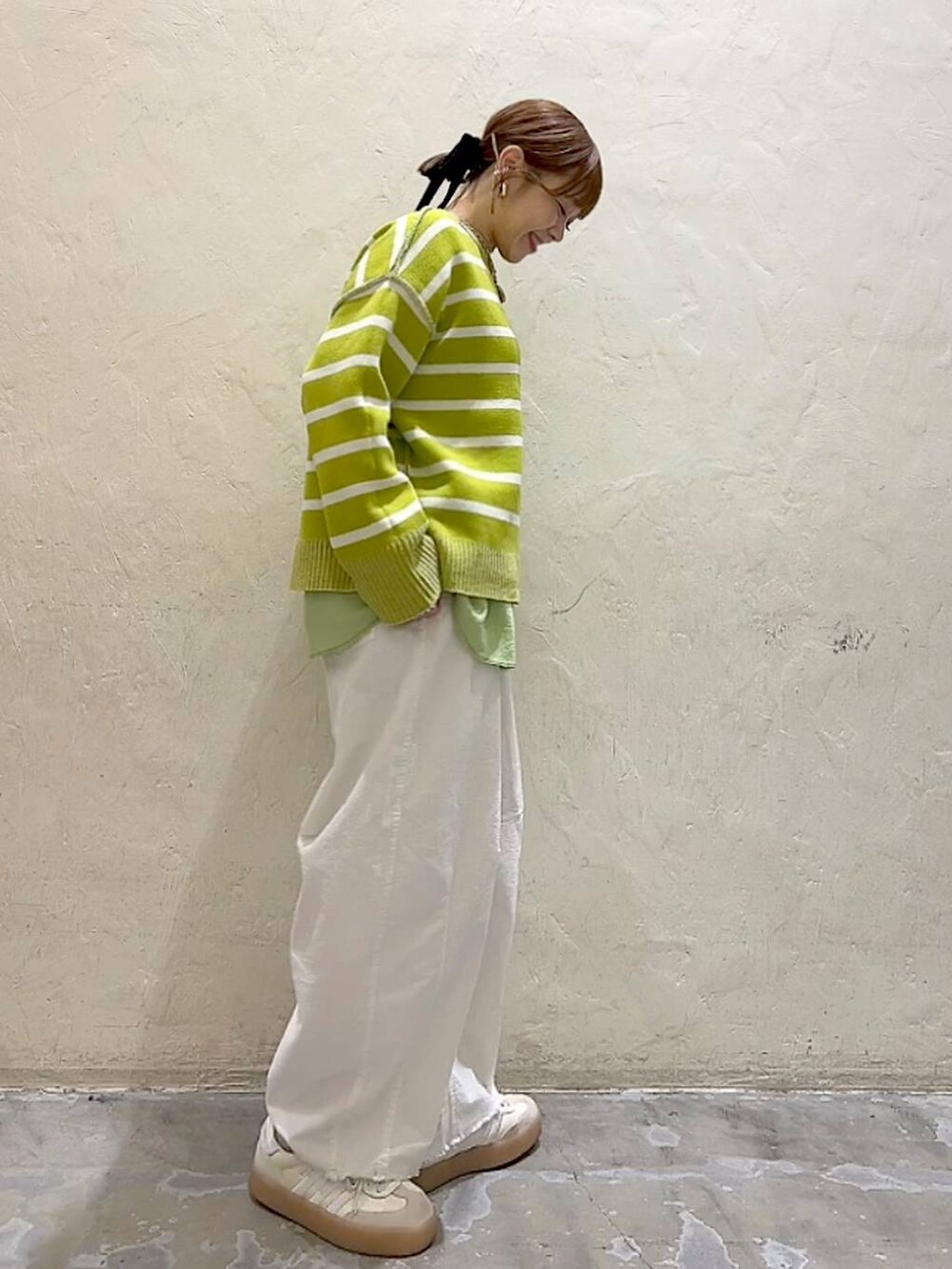 ホワイト系のその他パンツ、シルバー系のショルダーバッグ、イエロー系のニット/セーターを着用したレディースの冬コーディネートの4枚目の写真