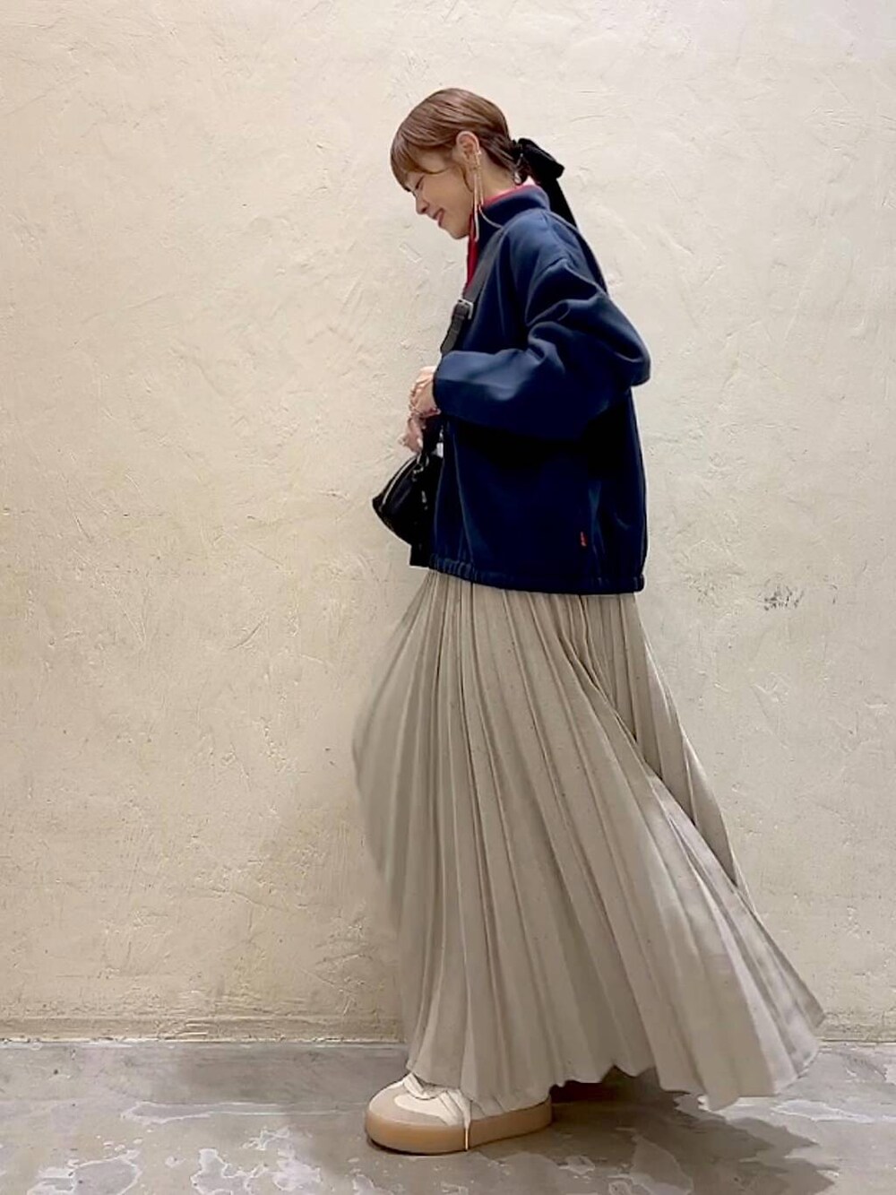 ブルー系のスウェット、ブラック系のショルダーバッグ、グレー系のスカートを着用したレディースの冬コーディネートの5枚目の写真