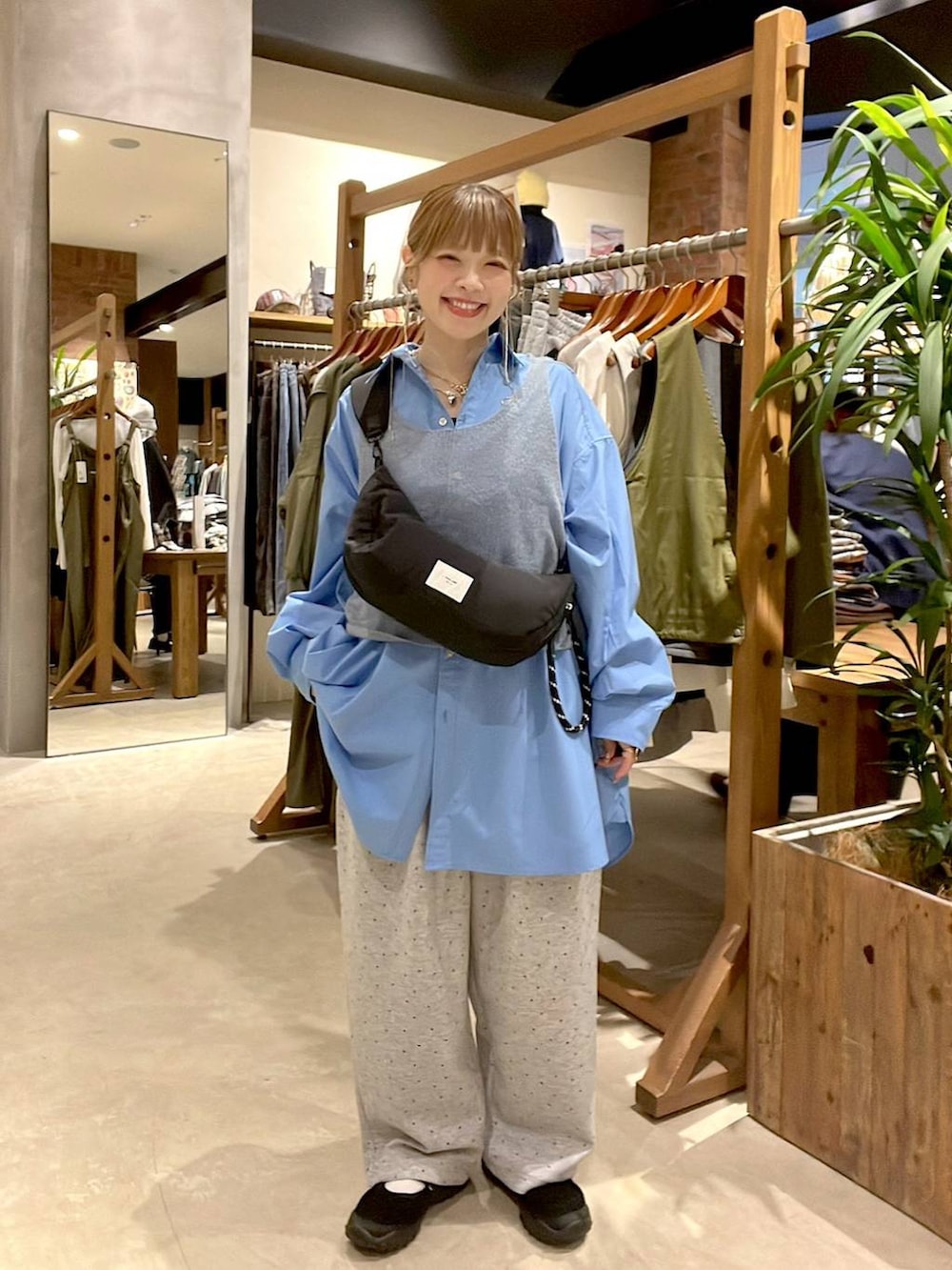 ブルー系のシャツ/ブラウス、ブラック系のショルダーバッグ、ブラウン系のチュニックを着用したレディースの秋コーディネートの4枚目の写真