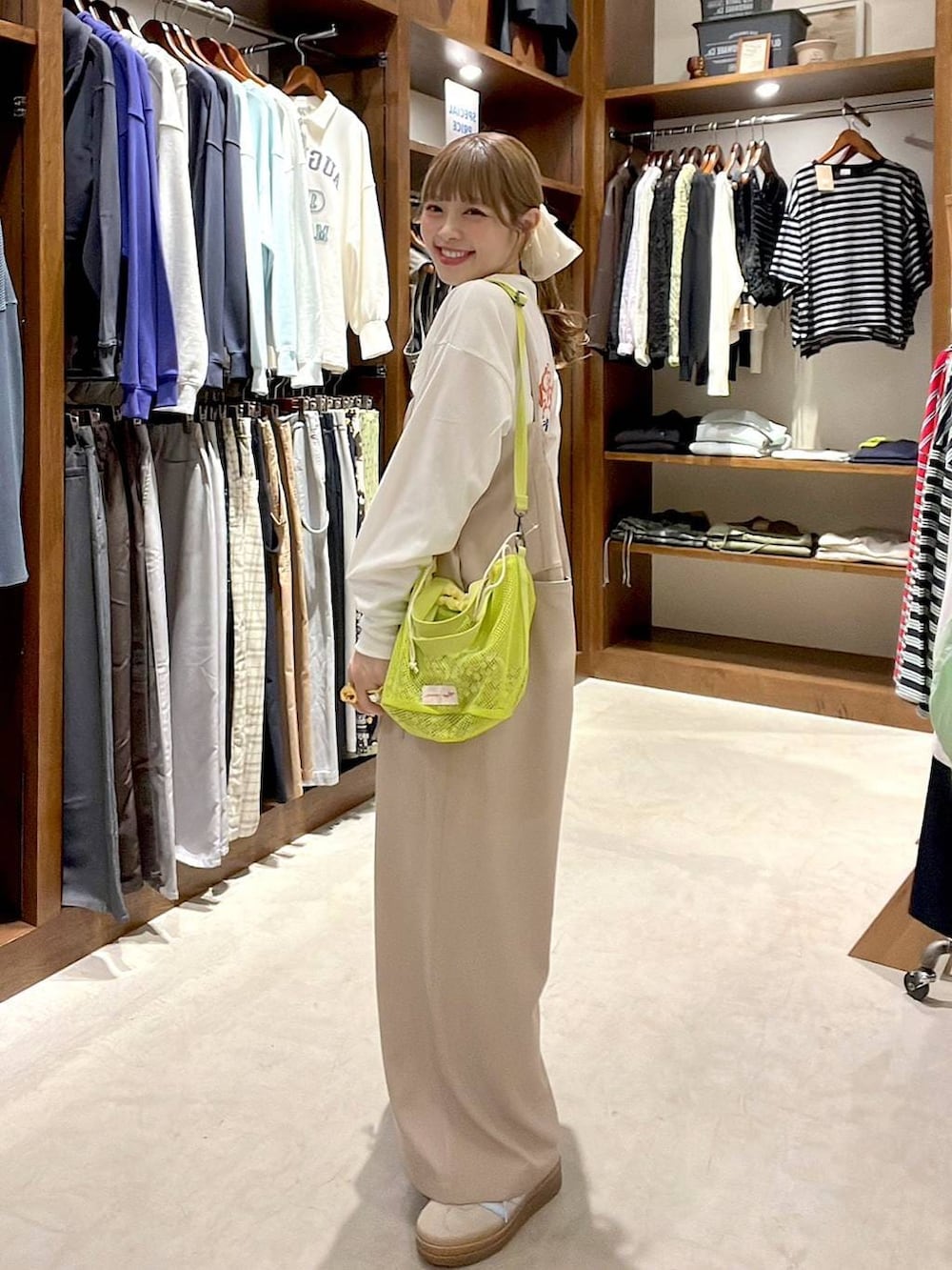 ベージュ系のスニーカー、イエロー系のショルダーバッグ、ホワイト系のヘアゴムを着用したレディースの春コーディネートの2枚目の写真
