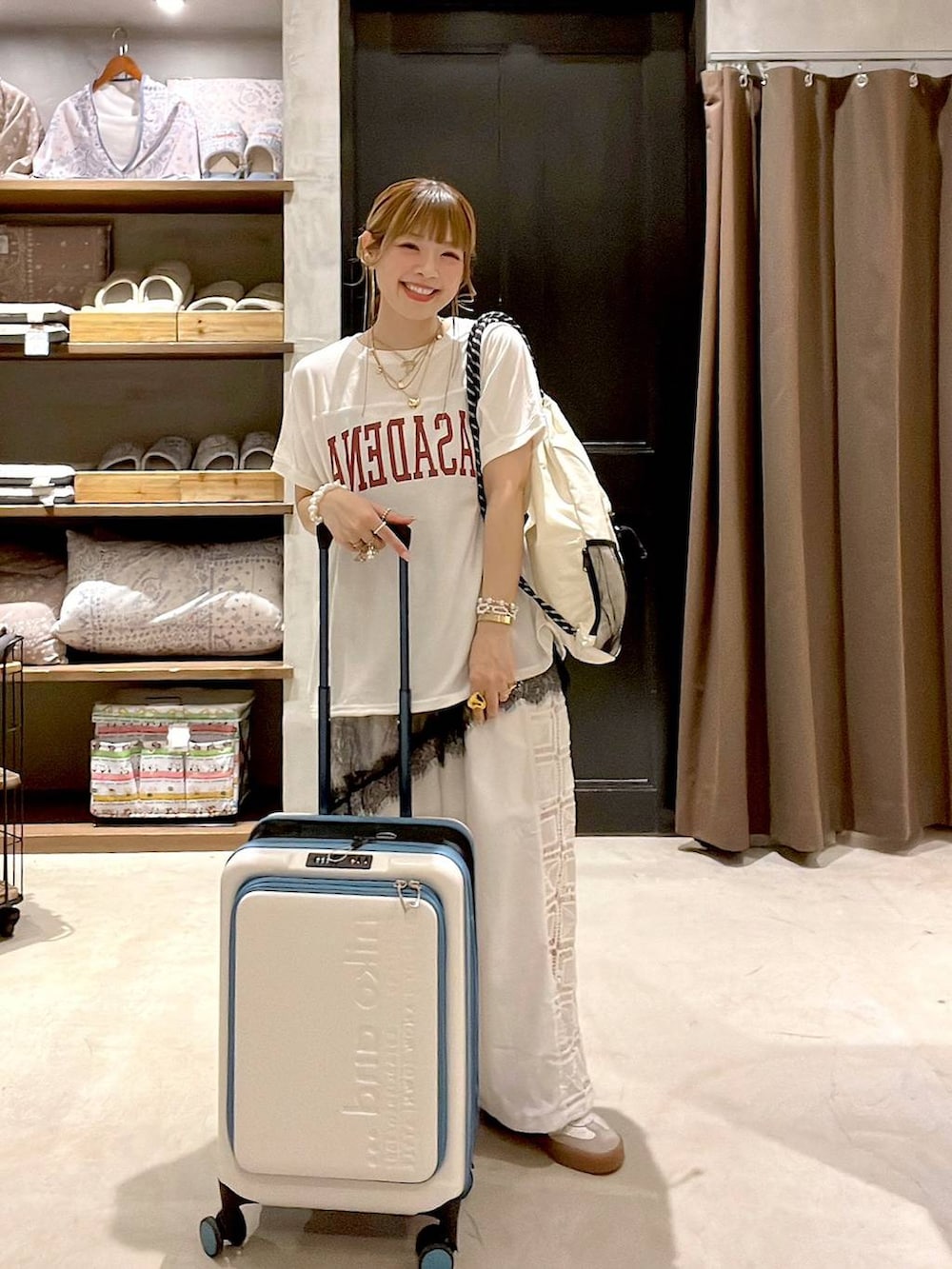ホワイト系のその他パンツ、ベージュ系のスーツケース/キャリーバッグ、ホワイト系のバックパック/リュックを着用したレディースの夏コーディネートの3枚目の写真