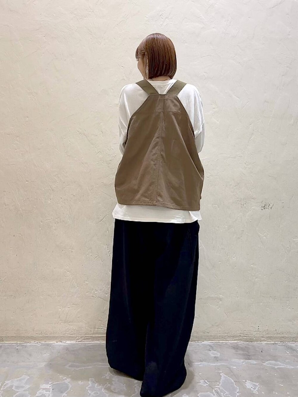 ホワイト系のTシャツ/カットソー、ブラック系のその他パンツ、ブラウン系のベストを着用したレディースの冬コーディネートの5枚目の写真