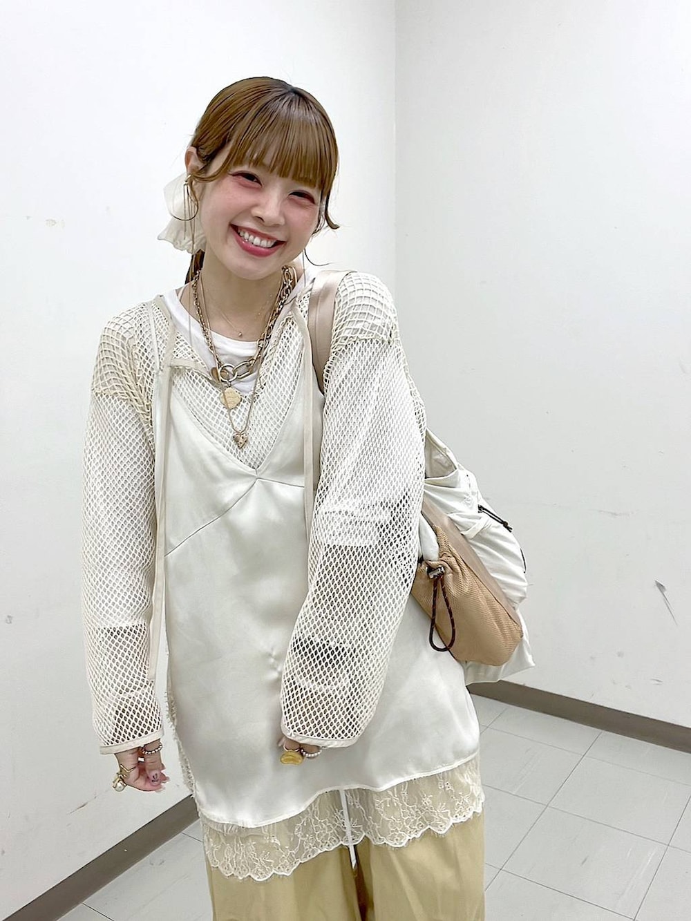 ホワイト系のTシャツ/カットソー、ベージュ系のスニーカー、ベージュ系のトートバッグを着用したレディースの春コーディネートの2枚目の写真