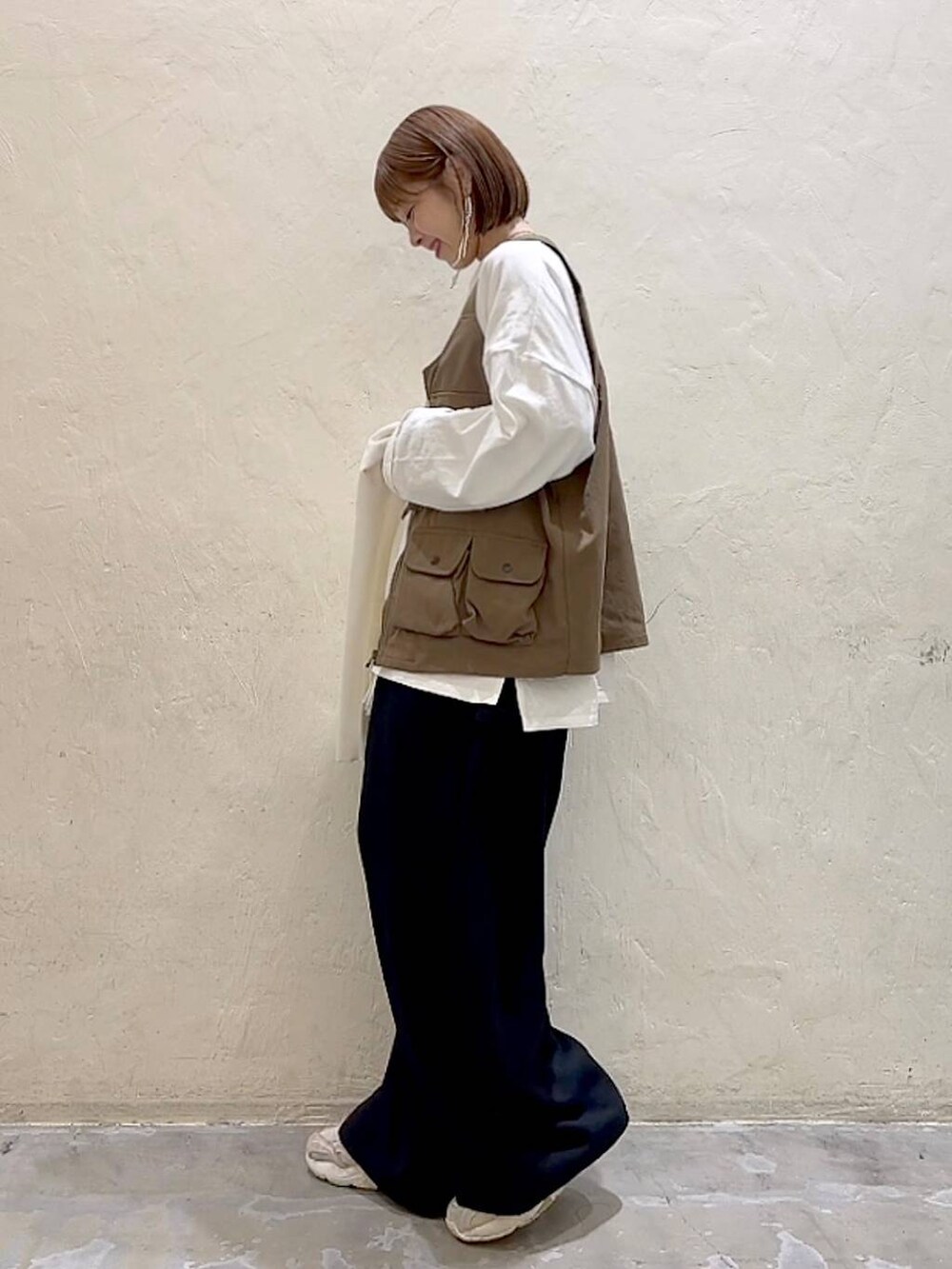 ホワイト系のTシャツ/カットソー、ブラック系のその他パンツ、ブラウン系のベストを着用したレディースの冬コーディネートの6枚目の写真