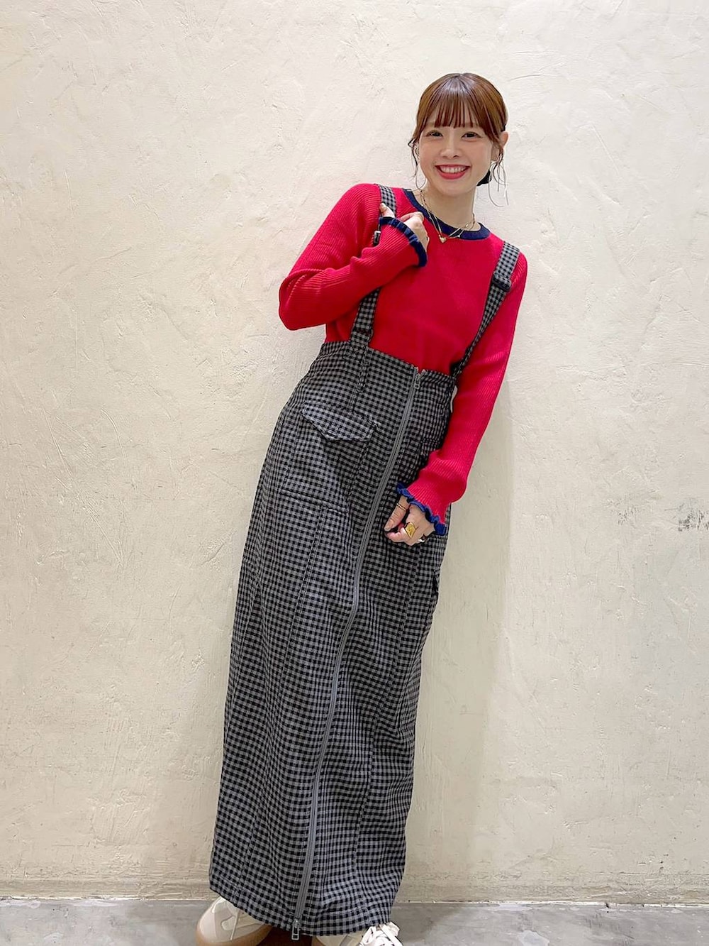 ブラック系のスカート、レッド系のニット/セーターを着用したレディースの秋コーディネートの3枚目の写真