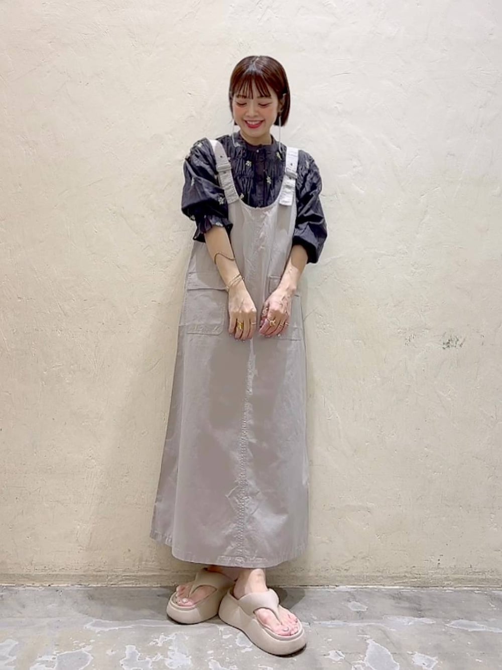 ベージュ系のサンダル、ブラック系のシャツ/ブラウス、グレー系のジャンパースカートを着用したレディースの春コーディネートの6枚目の写真