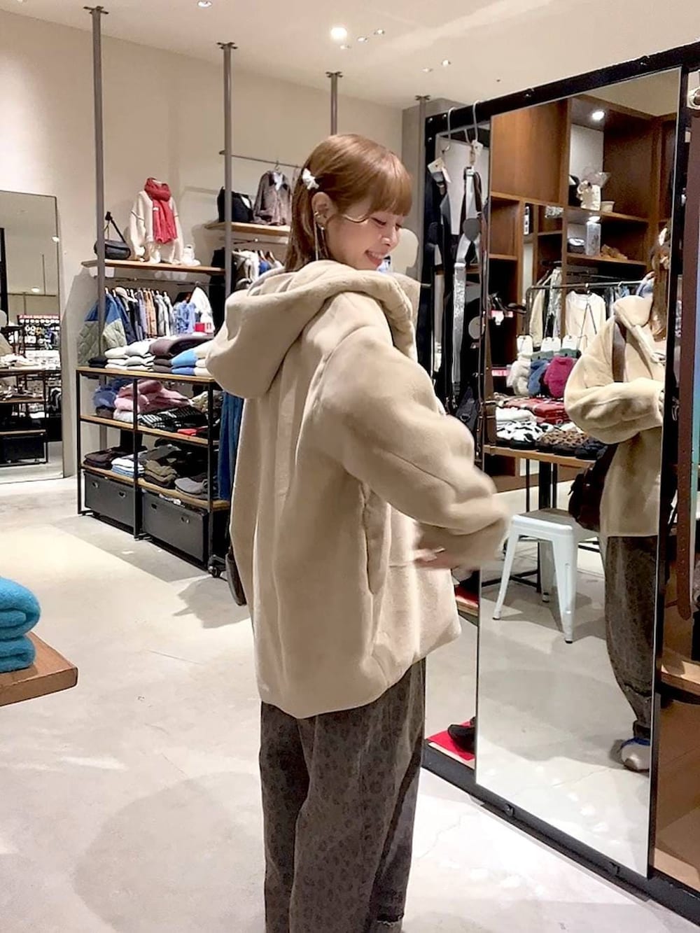 ブラウン系のデニムパンツ、ベージュ系のブルゾン、ブラウン系のショルダーバッグを着用したレディースの冬コーディネートの9枚目の写真