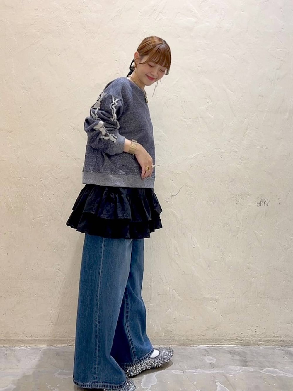 シルバー系のバレエシューズ、ブルー系のデニムパンツ、ブルー系のスウェットを着用したレディースの冬コーディネートの3枚目の写真