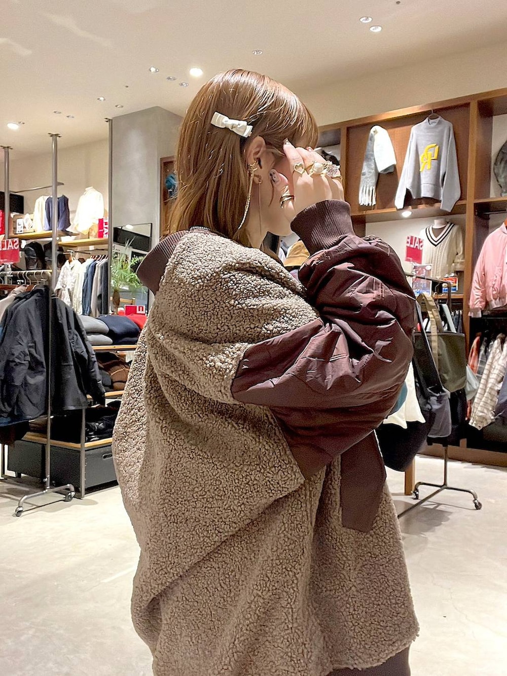 ホワイト系のTシャツ/カットソー、レッド系のMA-1、ブラウン系のスカートを着用したレディースの冬コーディネートの6枚目の写真