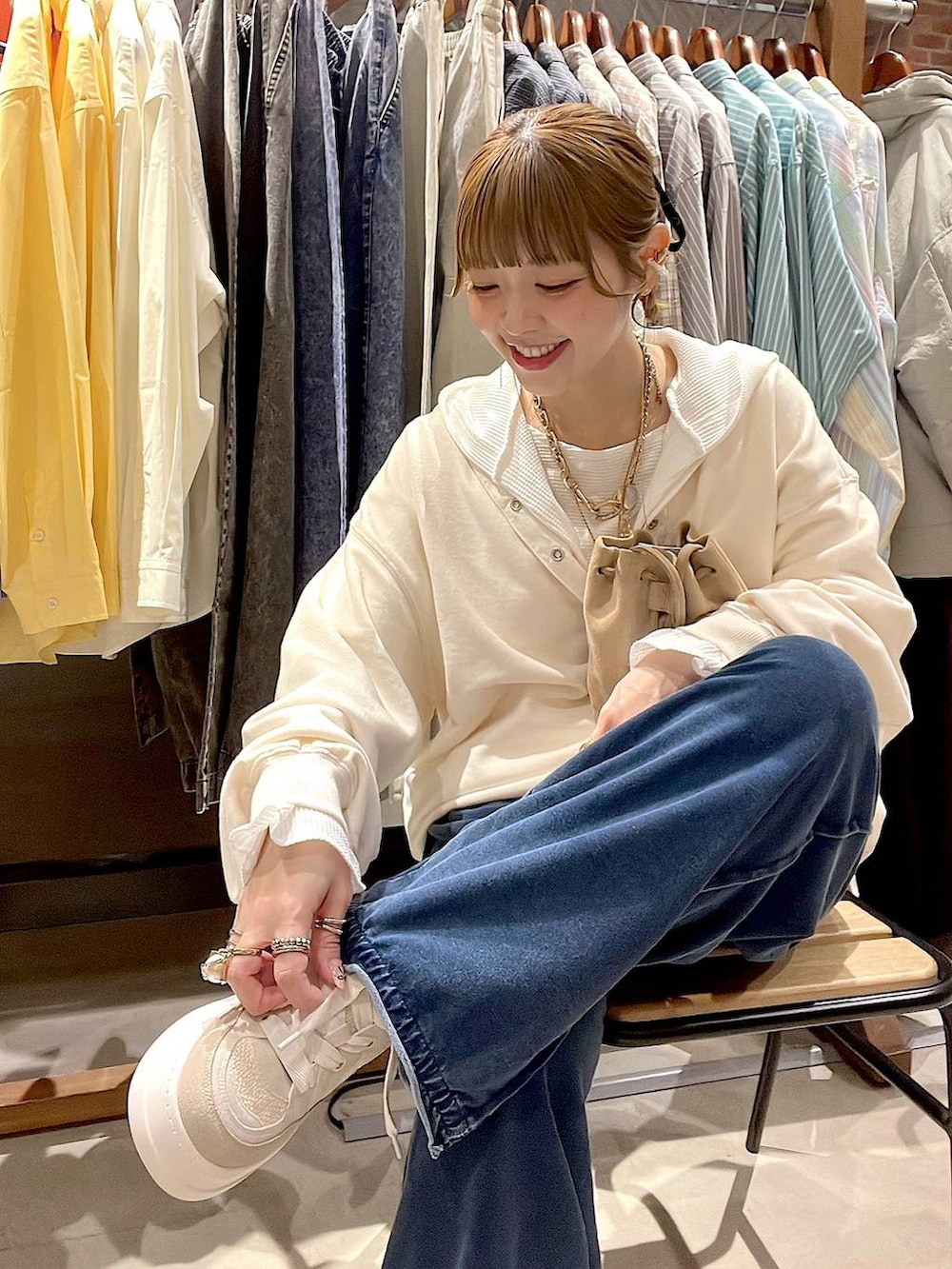 ベージュ系のショルダーバッグ、ホワイト系のパーカー、ホワイト系のTシャツ/カットソーを着用したレディースの冬コーディネートの8枚目の写真