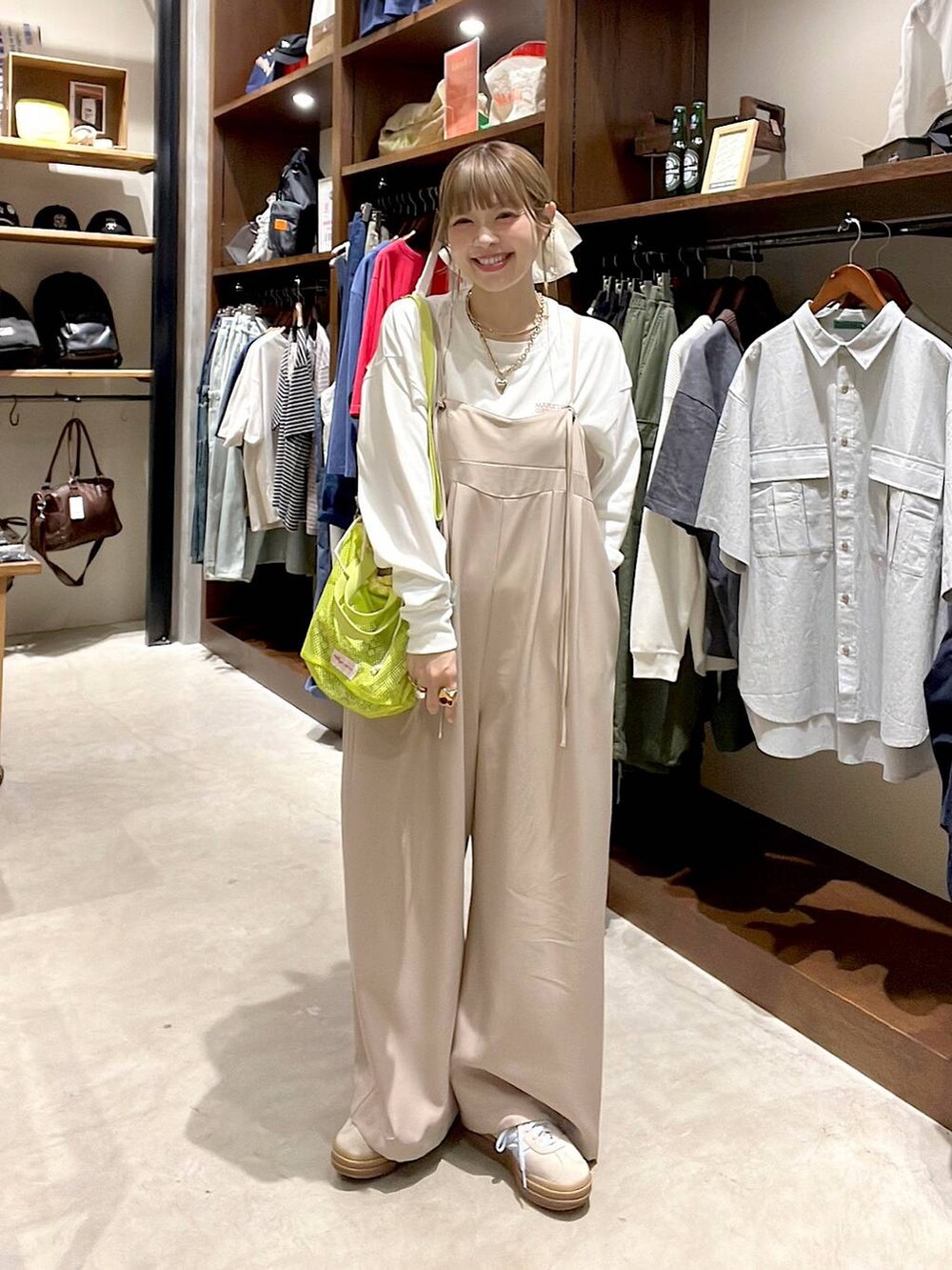 ベージュ系のスニーカー、イエロー系のショルダーバッグ、ホワイト系のヘアゴムを着用したレディースの春コーディネートの4枚目の写真