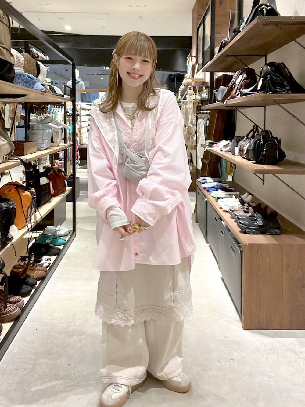 ベージュ系のデニムパンツ、ホワイト系のベスト、ピンク系のシャツ/ブラウスを着用したレディースの春コーディネートの2枚目の写真