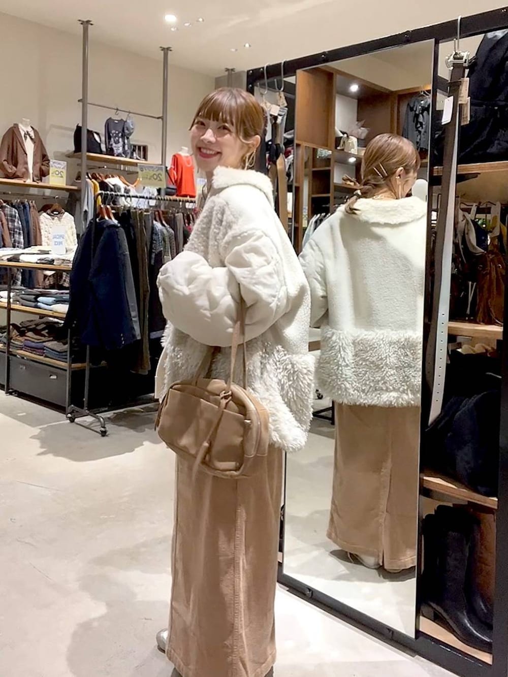 ベージュ系のブルゾン、イエロー系のスカート、ベージュ系のボストンバッグを着用したレディースの秋コーディネートの6枚目の写真